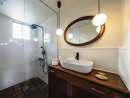 浴室の床はイタリアの古建築から再生利用。アンティーク家具を加工し、ボウルを載せて造作した洗面台。